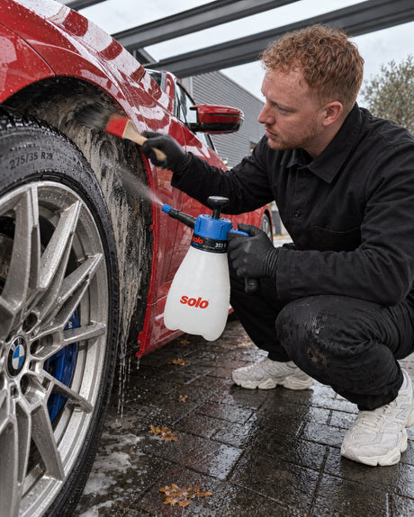 solo CLEANLine 303 B sprüht Reiniger in den Radkasten, Koch-Chemie Pinsel reinigt die Radlaufkante am BMW M2