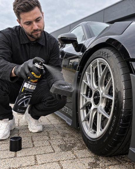 Detailing1 Meguiars Ultimate Insane Shine Tire Coating — Daniel sprüht das Coating auf das Applikator-Pad am Porsche 911 GT3
