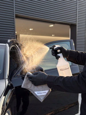 Sprühnebel der Glas Star Sprühflasche trifft Pro Glass Towel in Hand mit schwarzem Nitrilhandschuh am Audi RS3