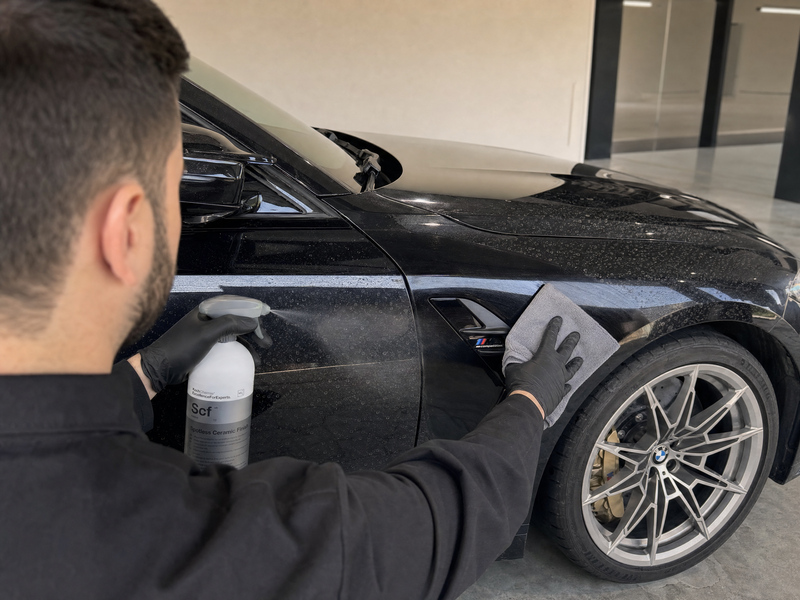 Applying Koch-Chemie Spotless Ceramic Finish with a microfibre towel on ceramic-coated BMW paint