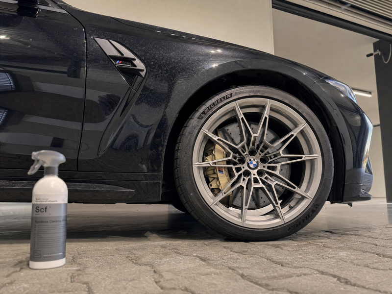 Black BMW M3 with water spots on the ceramic coating next to Koch-Chemie Spotless Ceramic Finish