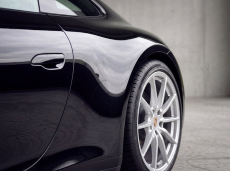 Saubere schwarze Porsche 911 Heckflanke nach der Behandlung mit streifenfreier Silberfelge ohne Flugrost-Punkte